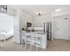 A kitchen with white cabinets and a stainless steel refrigerator.