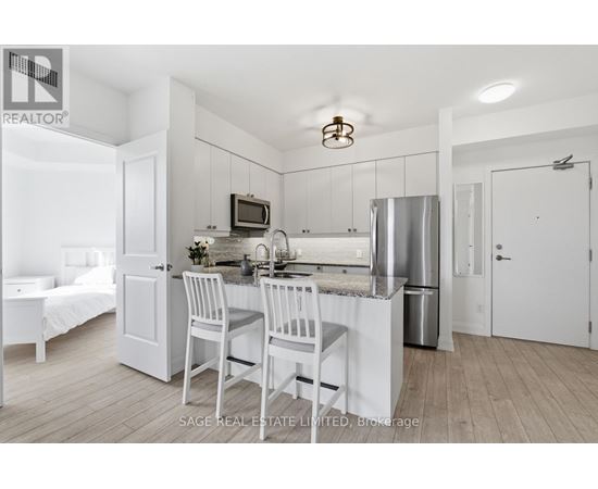 A kitchen with white cabinets and a stainless steel refrigerator.