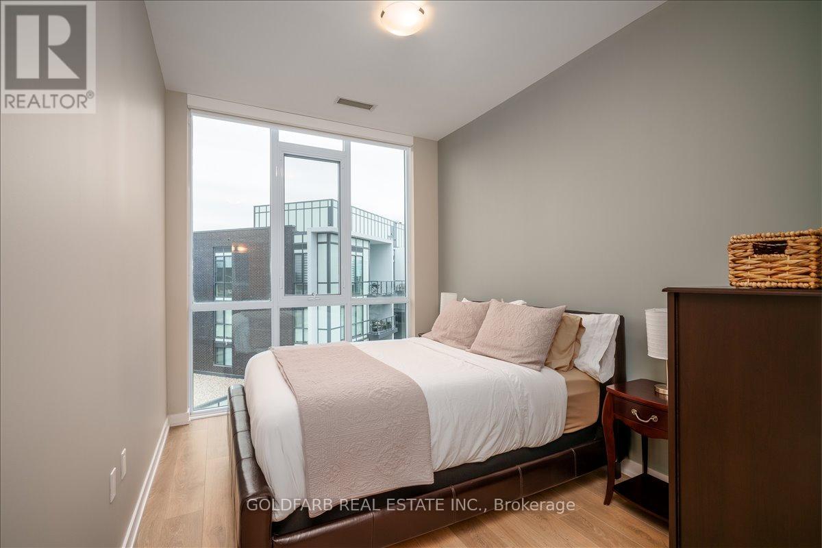 A bedroom with a large bed and a view of a cityscape outside the window.
