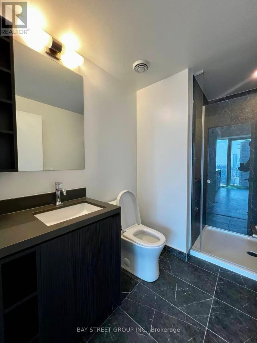 A bathroom with a sink, toilet and a mirror.