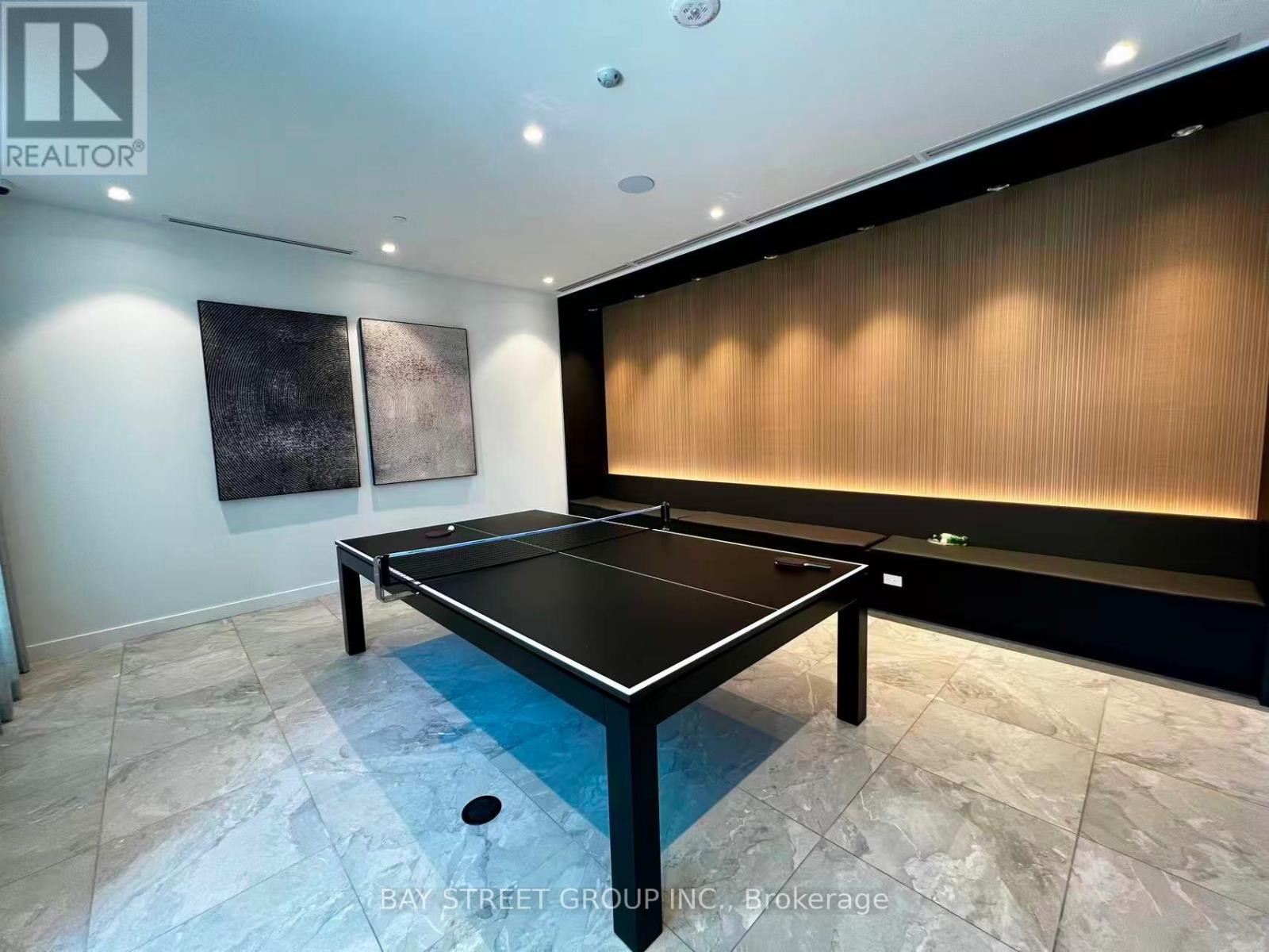 A black pool table in a room with a wooden wall paneling.