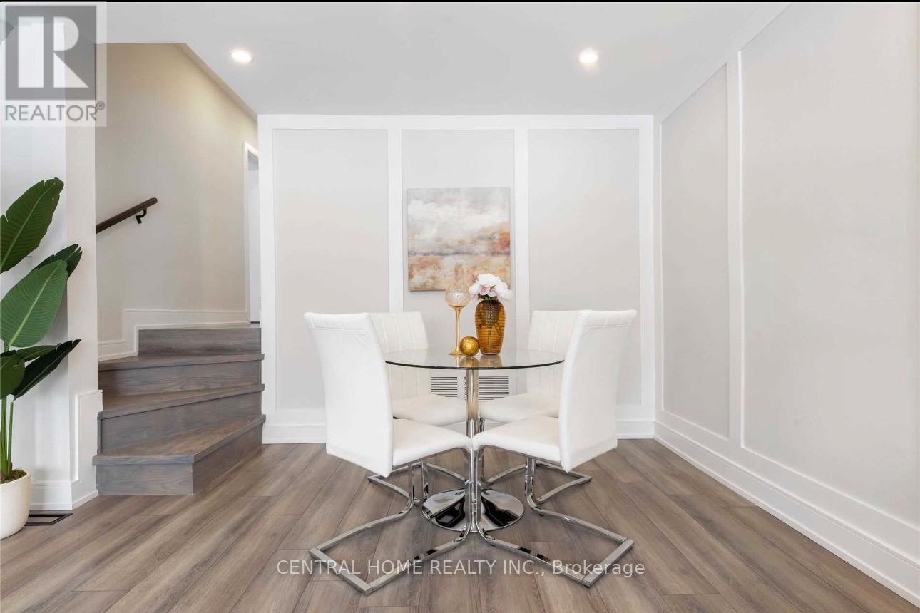A dining room with a glass table and white chairs.