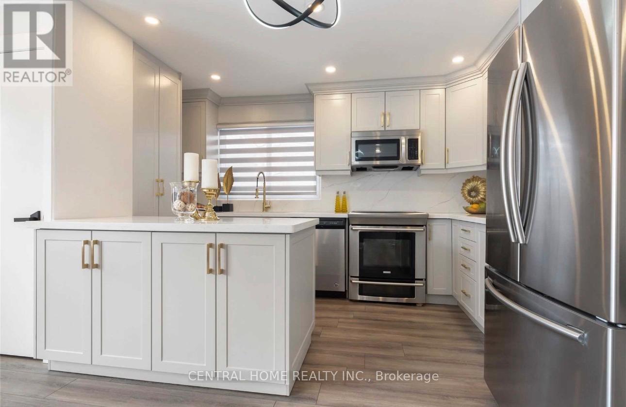 A modern kitchen with a stainless steel refrigerator and white cabinets.