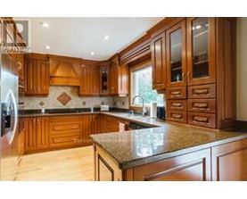 A kitchen with wooden cabinets and a marble countertop.