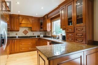 A kitchen with wooden cabinets and a marble countertop.