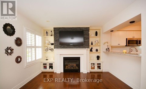 A living room with a fireplace and a tv on the wall.