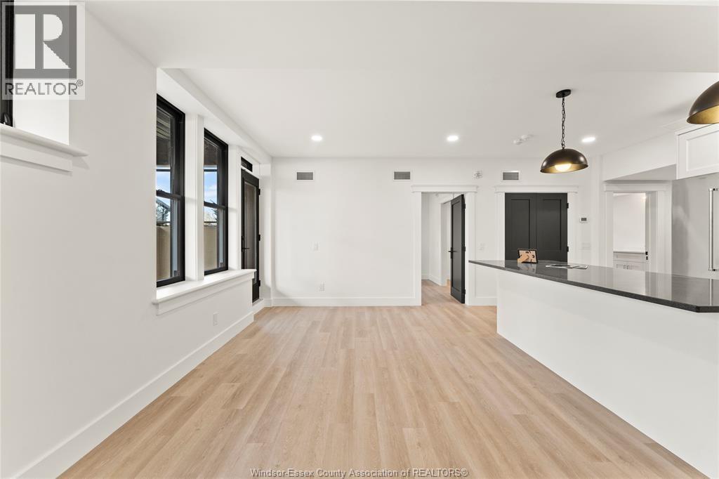 A spacious room with wooden flooring and white walls.