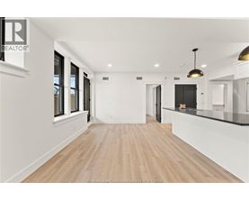 A spacious room with wooden flooring and white walls.