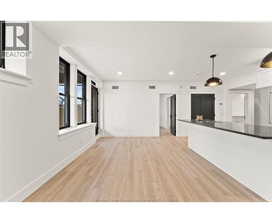 A spacious room with wooden flooring and white walls.
