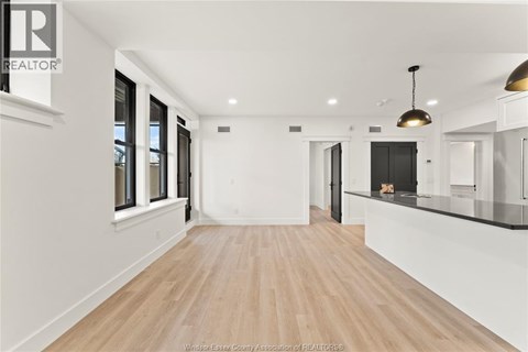 A spacious room with wooden flooring and white walls.