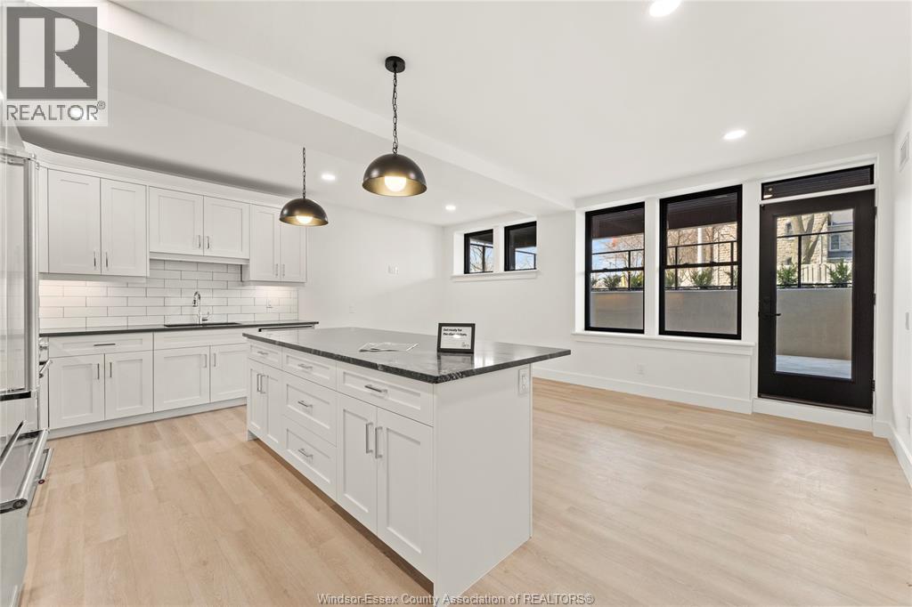A modern kitchen with white cabinets and a black countertop.