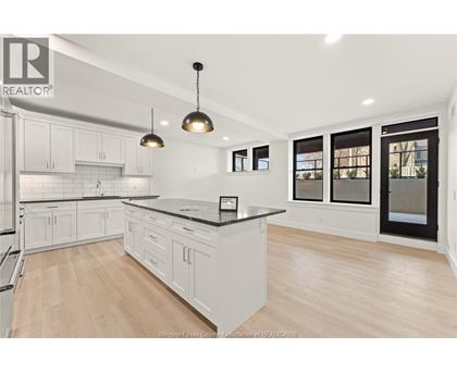 A modern kitchen with white cabinets and a black countertop.