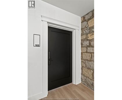 A black door with a white frame and a number 102 on the wall above it.