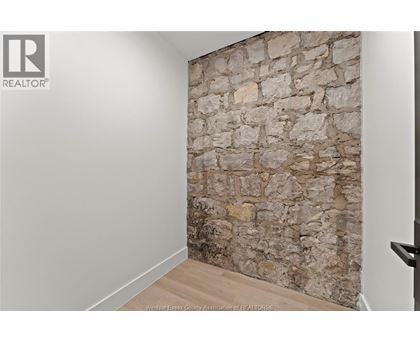 A stone wall in a room with a wooden floor.