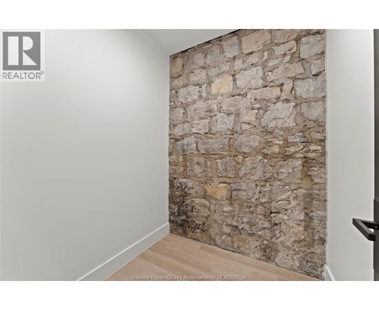 A stone wall in a room with a wooden floor.
