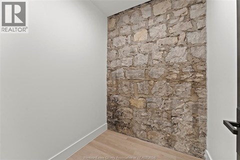 A stone wall in a room with a wooden floor.