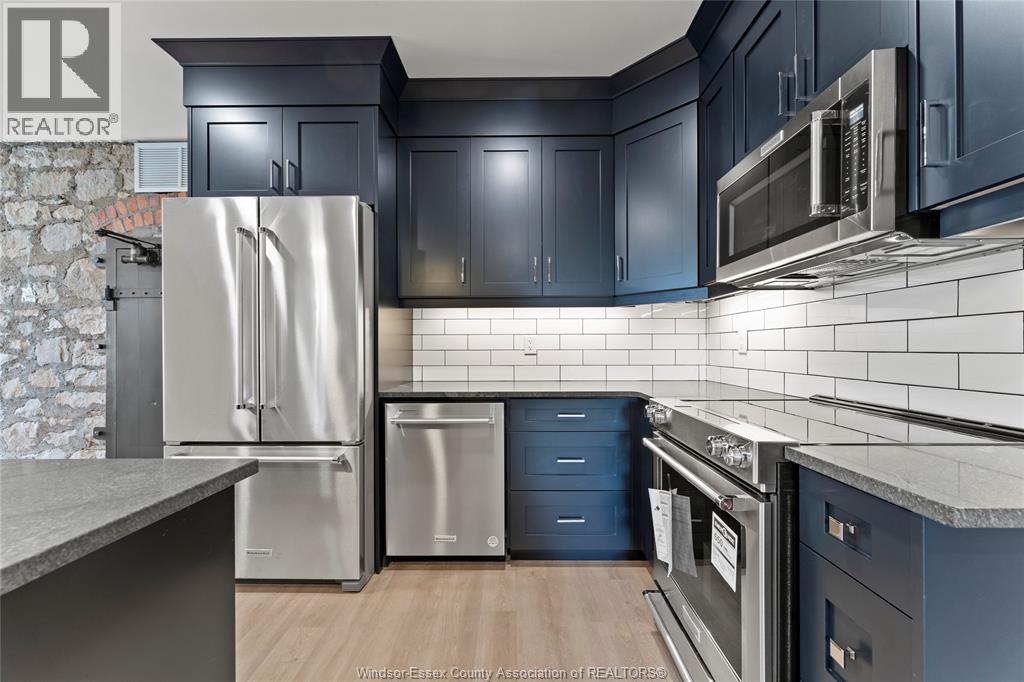 A kitchen with a stainless steel refrigerator and microwave.