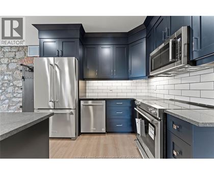 A kitchen with a stainless steel refrigerator and microwave.