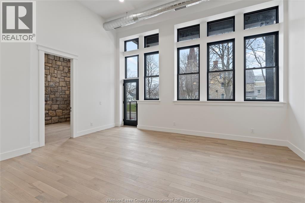 A spacious room with a brick wall and large windows.