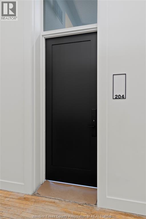 A black door with a white frame and a number 204 on the wall.
