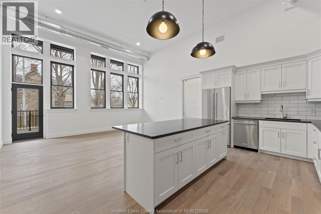 A modern kitchen with white cabinets and a black countertop.