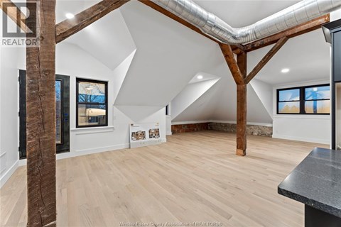 A spacious room with wooden floors and a large wooden beam on the ceiling.