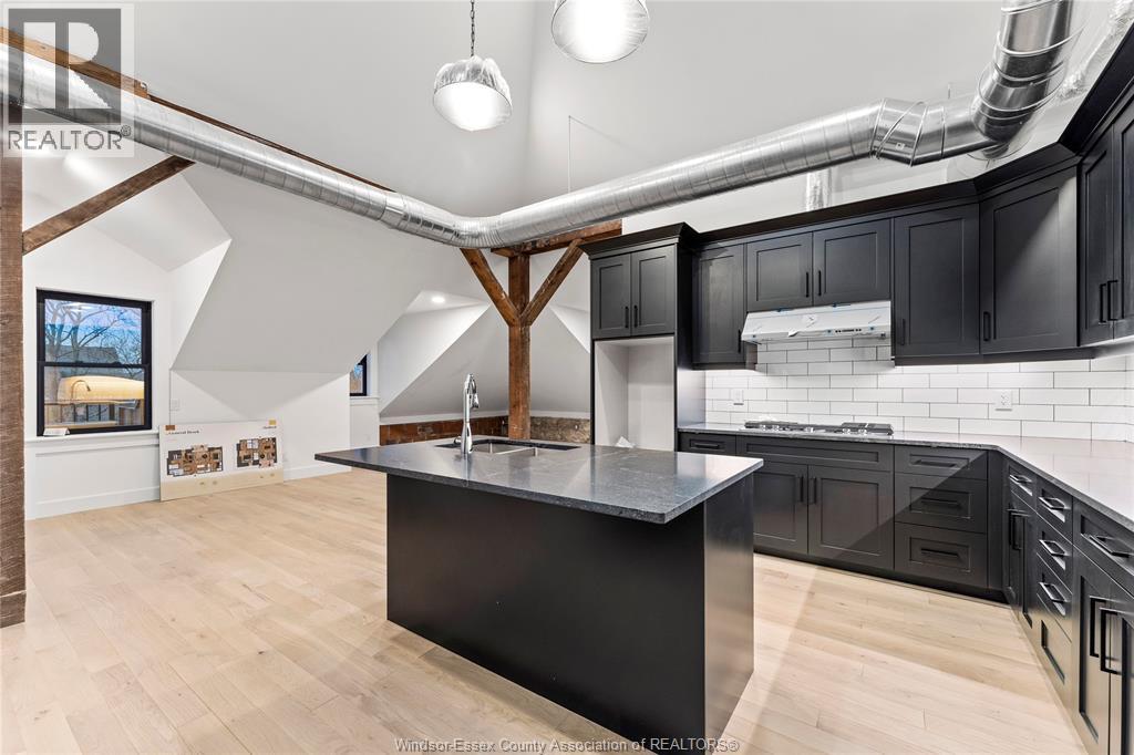 A kitchen with a black countertop and wooden cabinets.