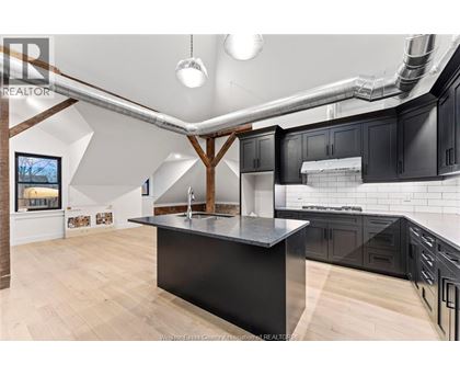 A kitchen with a black countertop and wooden cabinets.