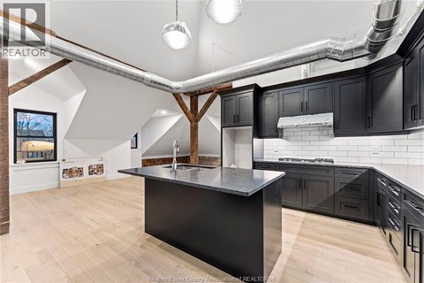 A kitchen with a black countertop and wooden cabinets.