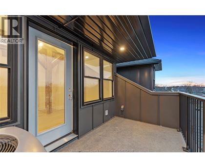 A balcony with a railing and a sliding glass door.
