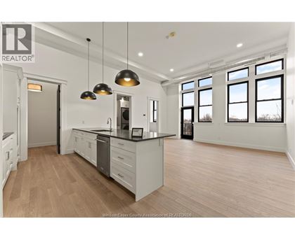 A well-lit kitchen with wooden floors and a large island.