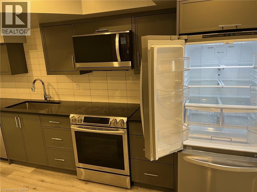 A kitchen with a stove, oven, microwave, and refrigerator.