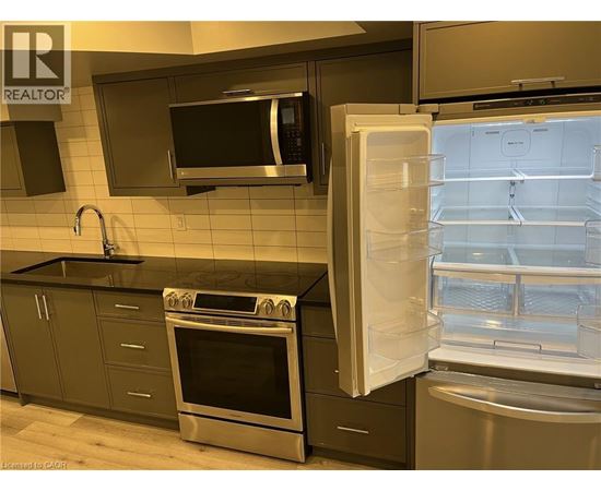 A kitchen with a stove, oven, microwave, and refrigerator.