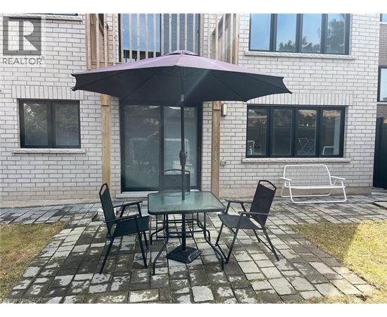 A table with chairs and an umbrella is set up outside a building.