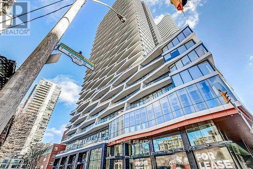 A tall building with a glass facade and a sign that reads "PRIME RENTALS" is seen in the foreground.