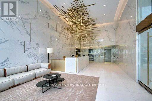 A spacious lobby with a marble floor and a white sofa.