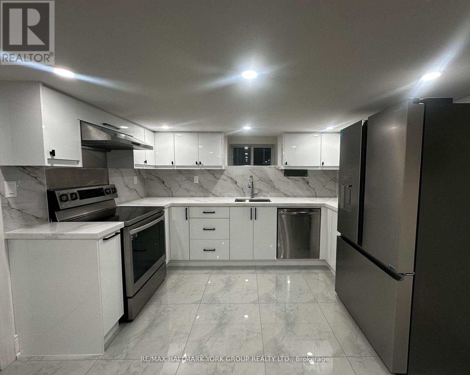 A kitchen with white cabinets and marble countertops.