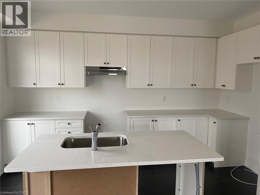 A kitchen with white cabinets and a sink.