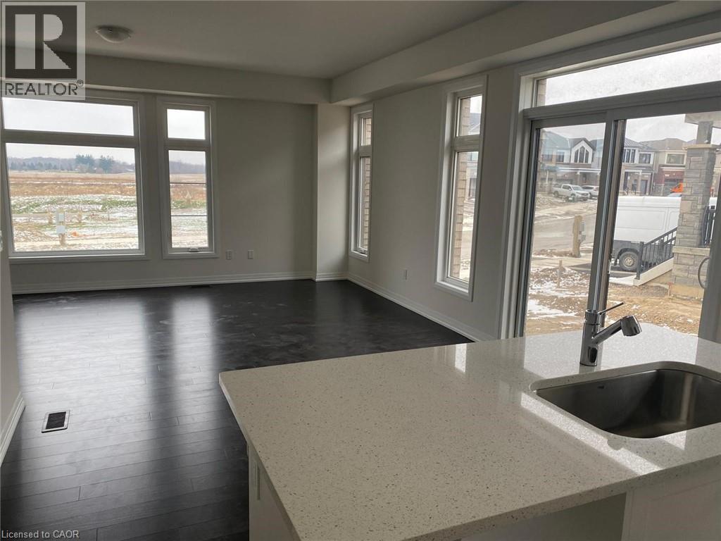 A large empty room with a sink and windows.