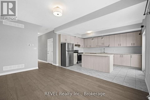 A kitchen with white cabinets and a wooden floor.