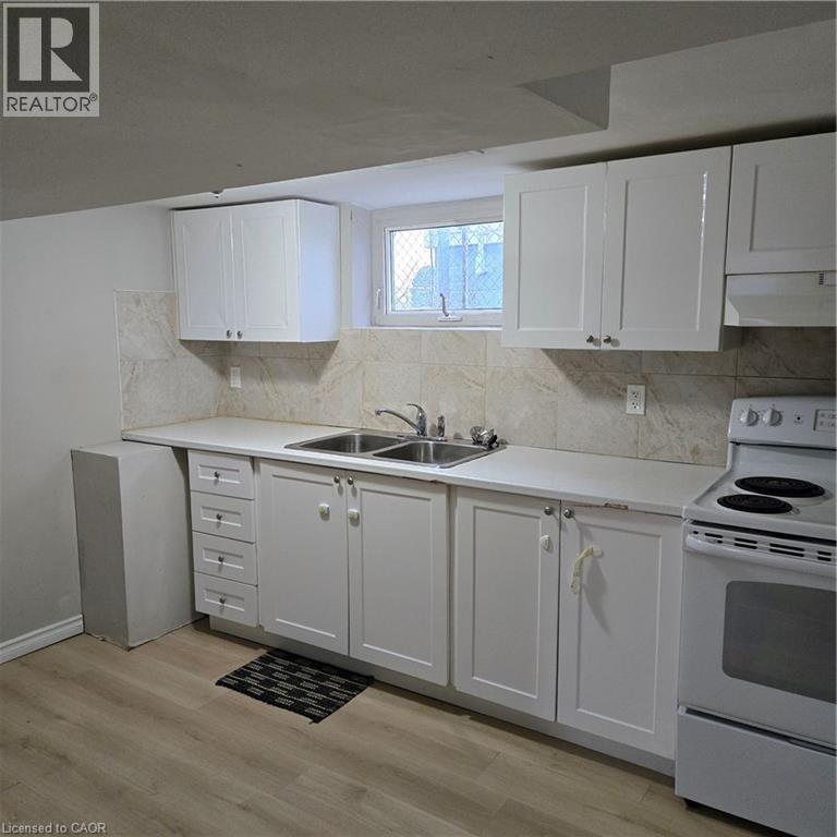 A kitchen with white cabinets and a white stove top oven.