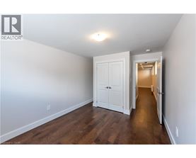 A white door is in a hallway with wood floors.