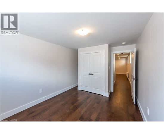 A white door is in a hallway with wood floors.