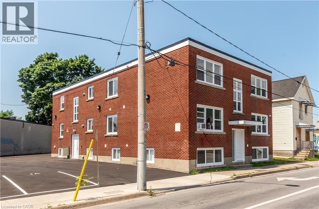 A red brick building with a no parking sign in front.
