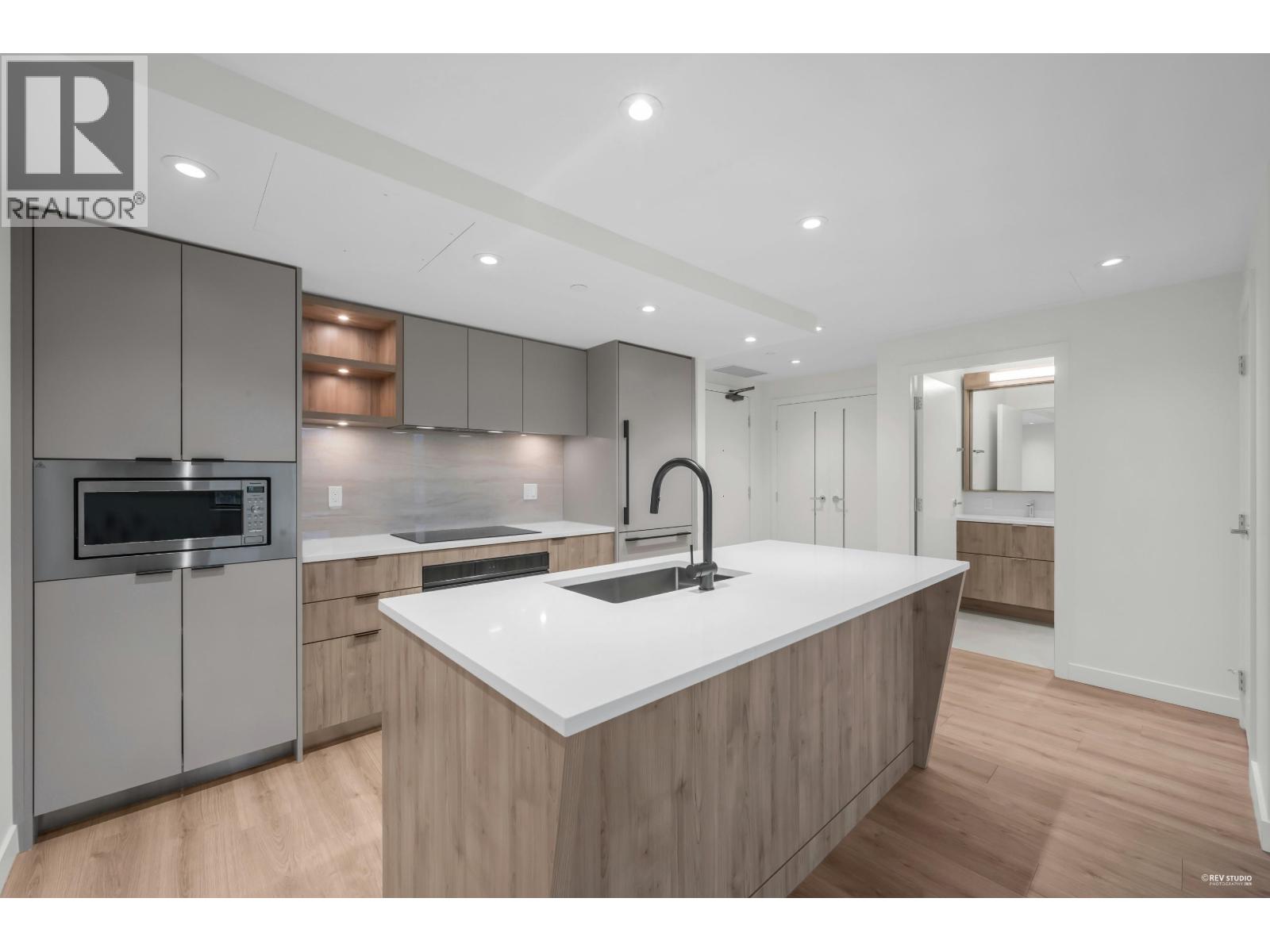 A modern kitchen with wooden cabinets and a white countertop.