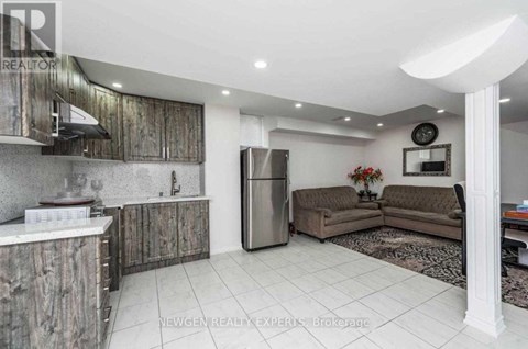 A kitchen with a refrigerator, a sink, and a counter.