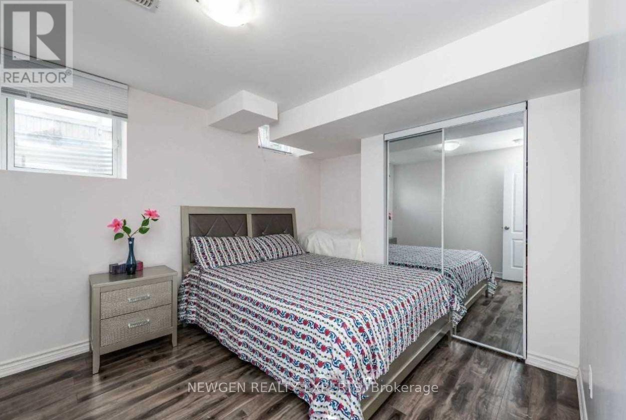 A bedroom with a bed, nightstand, and a window.