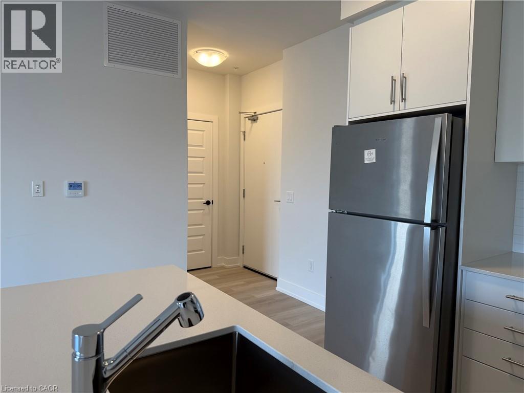 A modern kitchen with a stainless steel refrigerator and a sink.