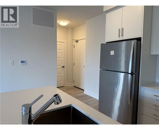 A modern kitchen with a stainless steel refrigerator and a sink.