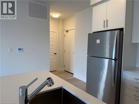 A modern kitchen with a stainless steel refrigerator and a sink.